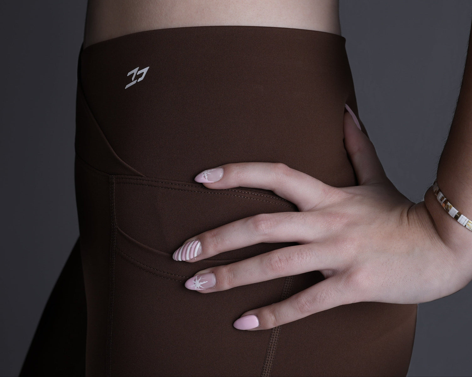 Brown athletic outfit with cut-out design on a dark background